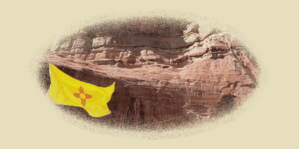 A flag bearing the Zia sun symbol before red canyon walls